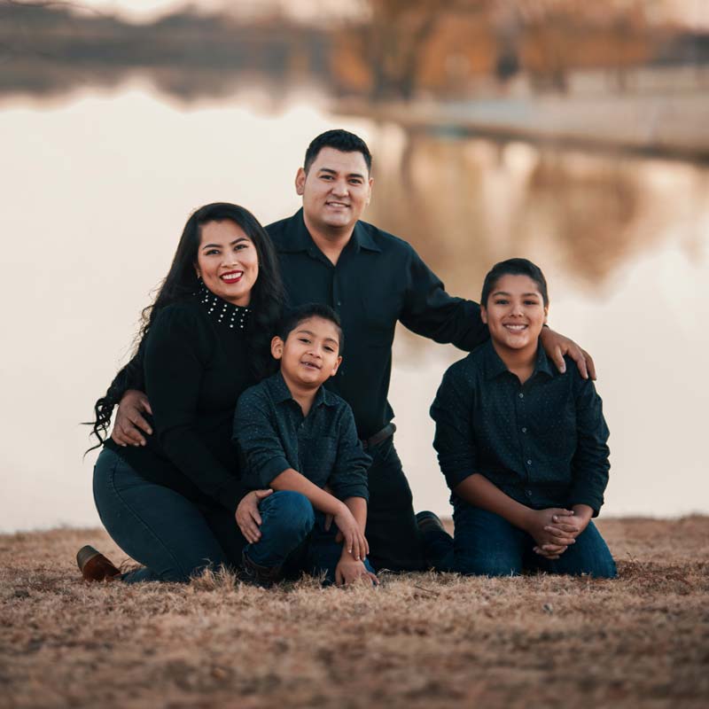 Smiling family posing by a lake