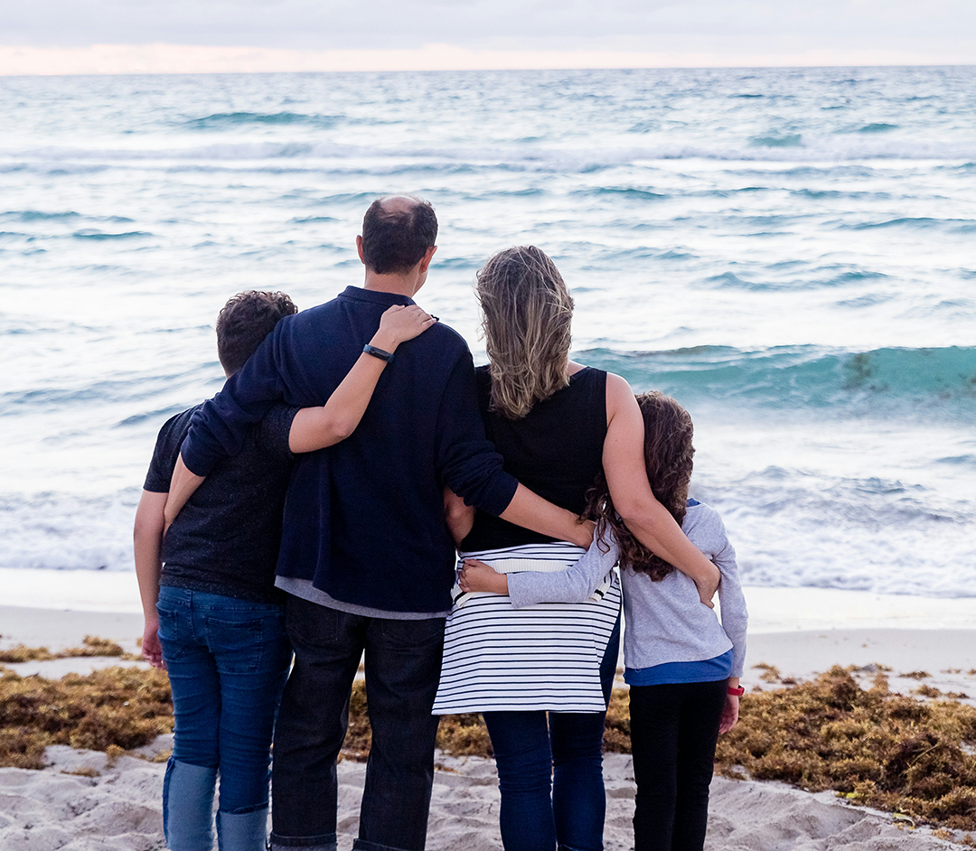 Family of 4 with their arms around one another